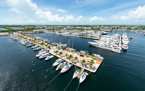 Elevated view of Stock Island Marina Village – FL Keys moorings, multiple motor yachts in attendance, surrounded by sea