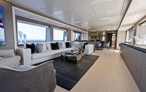 Tito El Patron main saloon with white L shaped sofa and dining table