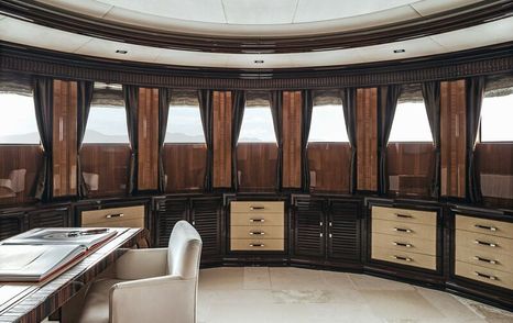 Study onboard M/Y MEAMINA, desk and white seat to port side with drawers and storage along far wall.