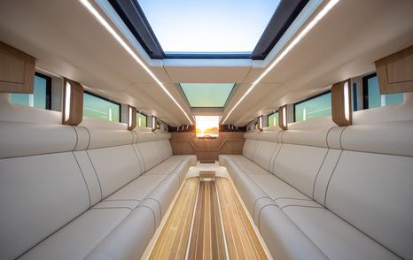 Light colored sofas, wooden decking and full length skylight interior of Onda 31L limousine tender