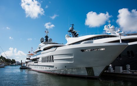 Superyachts moored at Superyacht Village FLIBS, surrounded by marina and blue sky