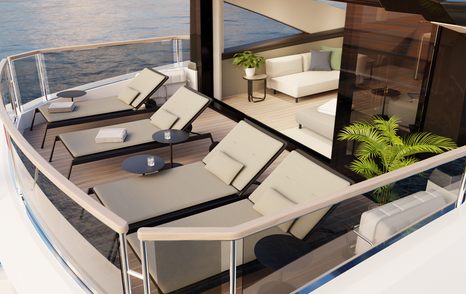 Exterior flybridge environment onboard Sunseeker Ocean 182. Four sun loungers face aft with interior visible through sliding doors.