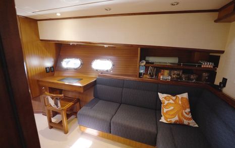 Nordhavn 75 EYF owner's suite seating area with desk, portlights and handcrafted timber joinery