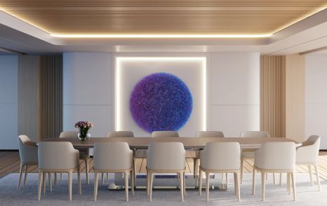 Landscape view of Feadship PURE dining area, long table surrounded by 12 chairs with purple artwork on wall.