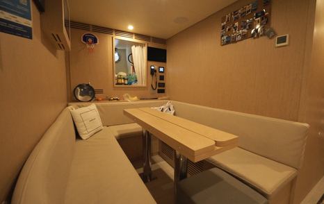 Custom Line Navetta 38 crew mess with seating area, dining table and access to galley and crew quarters