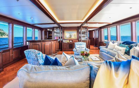 Superyacht Berilda's main saloon with L-shaped sofa and bar area