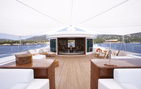 Expansive teak sun deck aboard Lady Christine with shaded canopy, white seating, and forward access to the observation lounge.