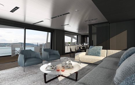 Main salon onboard Pershing GTX116. Grey sofa and armchairs surround a round coffee table, overlooking expansive windows.