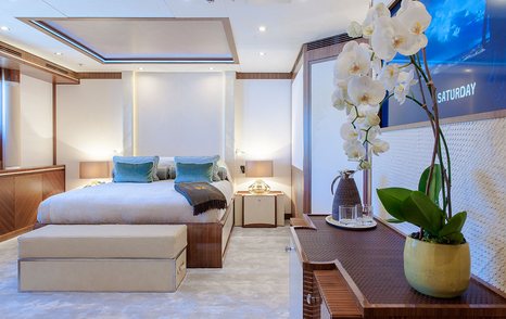 Cabin onboard Superyacht QUATTROELLE. Central berth with side tables and a flatscreen TV on starboard side.