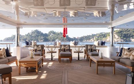 Superyacht Skyfall beach club with shaded seating and wooden coffee tables