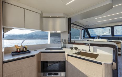 Galley onboard Absolute 50Fly, central oven appliance with sink to starboard, surrounded by wide windows