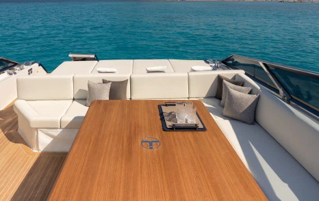 Itama 70 motor yacht aft with L-shaped seating and wooden table 
