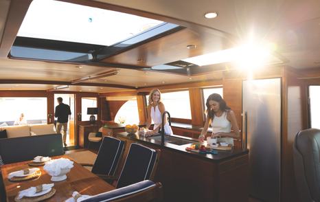 Woman preparing food inside the Palm Beach PB85 Sedan motor yacht saloon