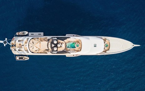 Aerial bird's eye view of Superyacht KISMET. Overlooking entire length of yacht with swimming pool and decks visible.