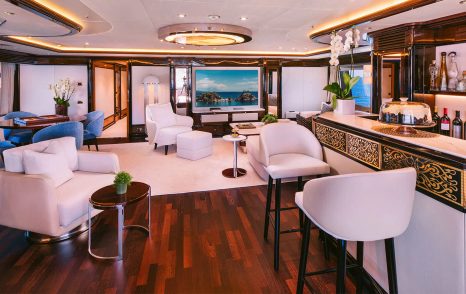 Superyacht Dilara's interior bar area with white furniture and central TV