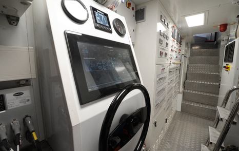 Custom Line Navetta 38 engine room control area with monitoring screens, switchboards and access stairs