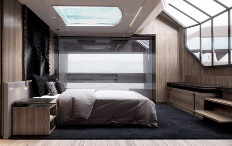 rendering of bed looked over by skylight in master suite with grained wooden wall panels on the Ilumen yacht Peppermint