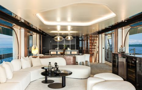 Horizon FD100 Skyline motor yacht saloon with curved white seating and forward dining and galley area 