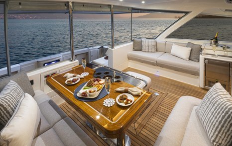 Riviera 64 Sports Motor Yacht Series II Yacht aft deck with alfresco dining and L-shaped sofa