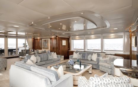 Superyacht Olympus main saloon seating area with coffee table and pale blue furniture