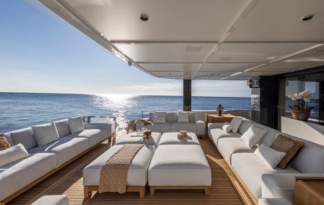 Arcadia A96 motor yacht aft deck with sunpads and white furniture