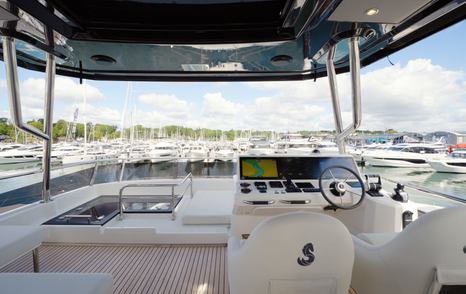 Beneteau Grand Trawler 63 flybridge helm station with excellent forward visibility and hardtop protection
