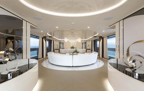 Mangusta Oceano 50 motor yacht main saloon interior with curved seating and abstract statues