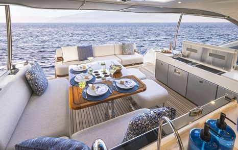 Riviera 5600 Sport Yacht Platinum Edition motor yacht aft deck with L-shaped grey seating and bbq