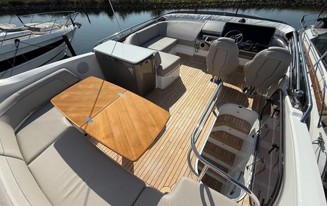 The flybridge on motor yacht F50, with helm station and dining area 