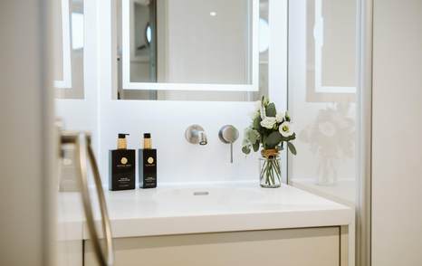 Ensuite bathroom on board motor yacht Scintilla Maris with white stone and a large mirror 