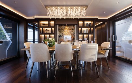 Interior dining area onboard Sirena Yachts 88, central dining table surrounded by eight chairs