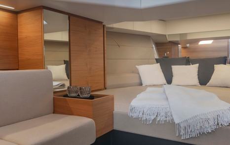 Interior of Wally 48 Wallytender, a small sofa to the left with adjoining shelf for drinks plus a double berth in the bow.