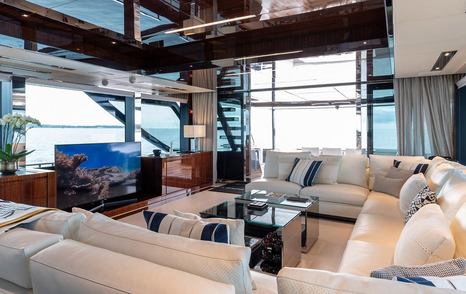 Superyacht Onyx's interior entertainment area with TV and U-shaped sofa