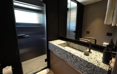 Benetti Oasis 34M guest cabin ensuite featuring stone vanity unit, walk-in shower and contemporary finishes.