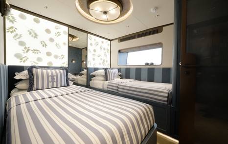 Sirena 118 blue twin guest cabin with striped berths and backlit panels