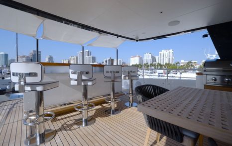 Benetti Oasis 34M sundeck bar with stools, grill station and outdoor entertaining area beneath the hardtop.