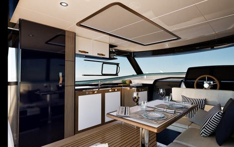 Rendering of Apreamare Gozzo 48 Cabin boat saloon with wooden table and helm station