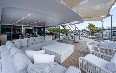 Superyacht Cofina's upper aft deck with L-shaped seating and alfresco dining