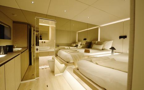 Sunreef Ultima 88 twin guest cabin with two single beds and mirrored bathroom wall
