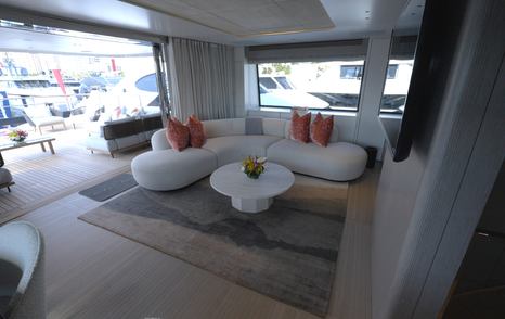 Benetti Oasis 34M sky lounge featuring curved sofa seating, television and floor-to-ceiling glazing.