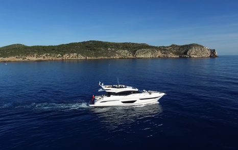 Princess S65 Mk2 underway in calm water off a rocky coastline