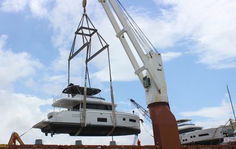 Sirena 58 on a crane, being lifted off a ship down to the sea.