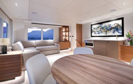Nordhavn 80 Motor Yacht salon with circular wooden table 
