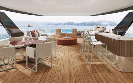 Overview of the sun deck onboard the Custom Line Navetta 50. Wet bar and stools to starboard side with table and seating to port.