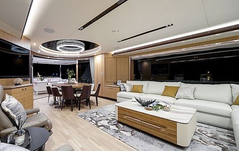 Main salon onboard Horizon TO-KALON, white sofa to starboard with low coffee table, dining table in background