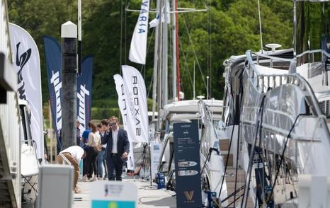 Overview of visitors to the British Motor Yacht Show walking the pontoons of Swanwick Marina with yachts for sale berthed adjacent