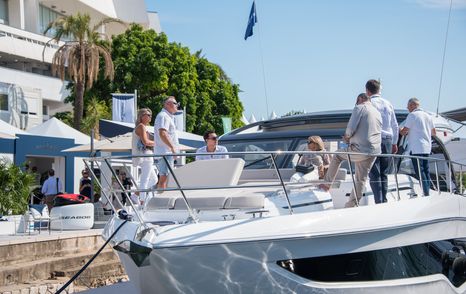 Visitors at the Cannes Yachting Festival standing on the bow of an attending yacht