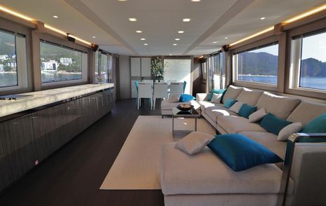 main salon on board flybridge yacht mcy 86, with wide windows and white sofas