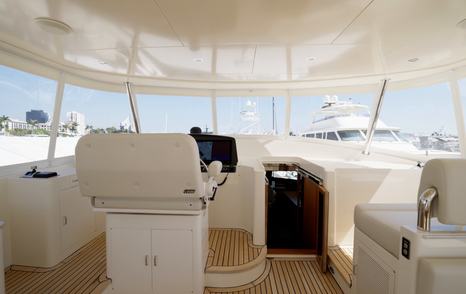 Fleming 85 enclosed flybridge helm area with companion seating and all-weather protection
