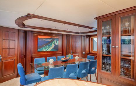 Superyacht Bang! main saloon aft dining area with blue dining chairs 